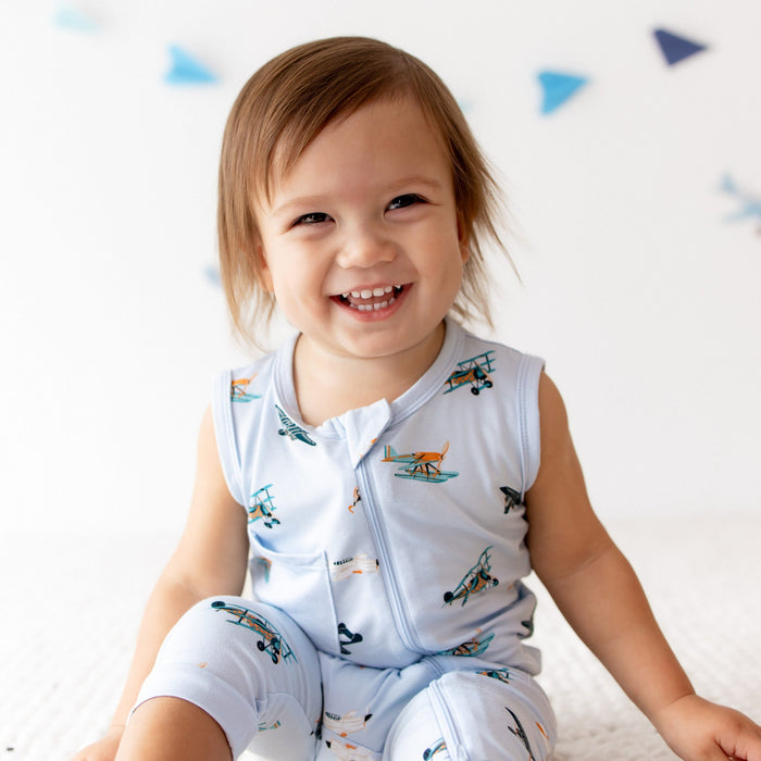 Close up of smiling toddler wearing the Zippered Sleeveless Romper in Take Off